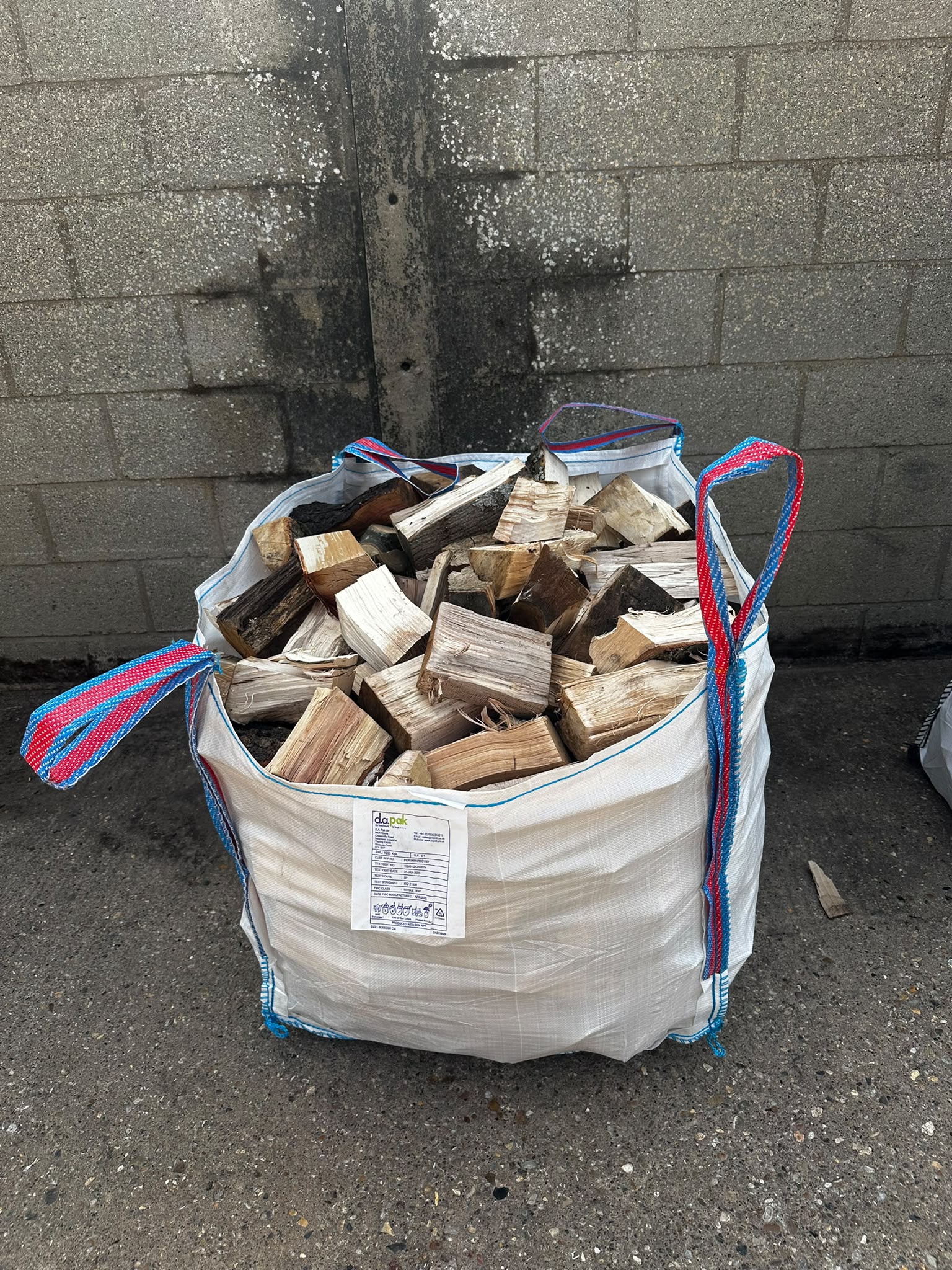 Red net bag filled with firewood logs