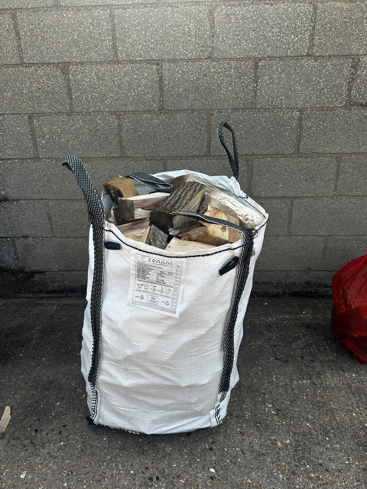 Large bulk bag filled with split firewood logs